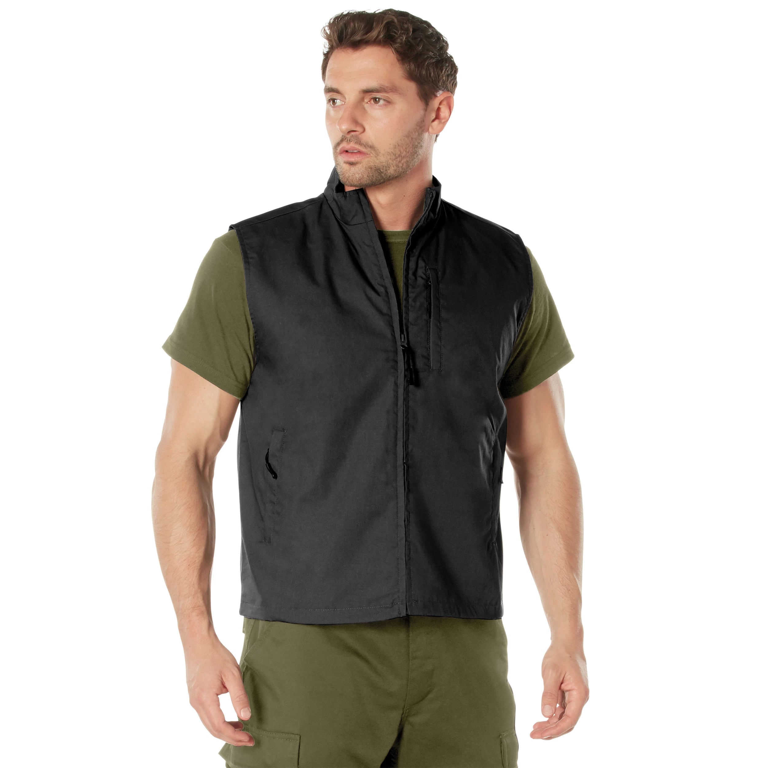 Man wearing a black vest over a green shirt and pants on a white background
