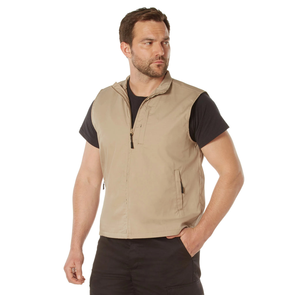 Man wearing a beige vest over a black shirt on a white background