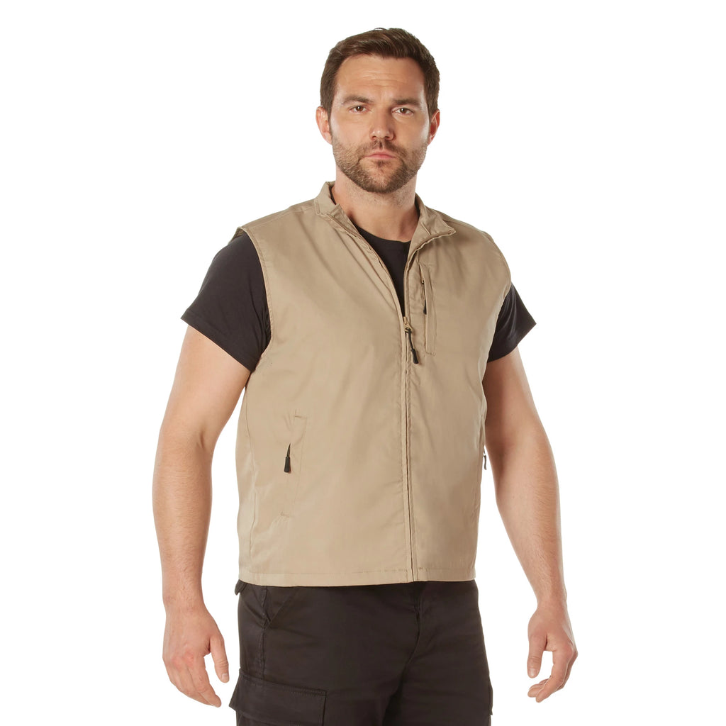 Man wearing a beige vest over a black shirt on a white background