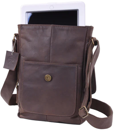 Rothco's Brown Leather Military Tech Bag, oblique front view with weather flap open showing front exterior accessory pocket, sample main compartment contents and shoulder sling.