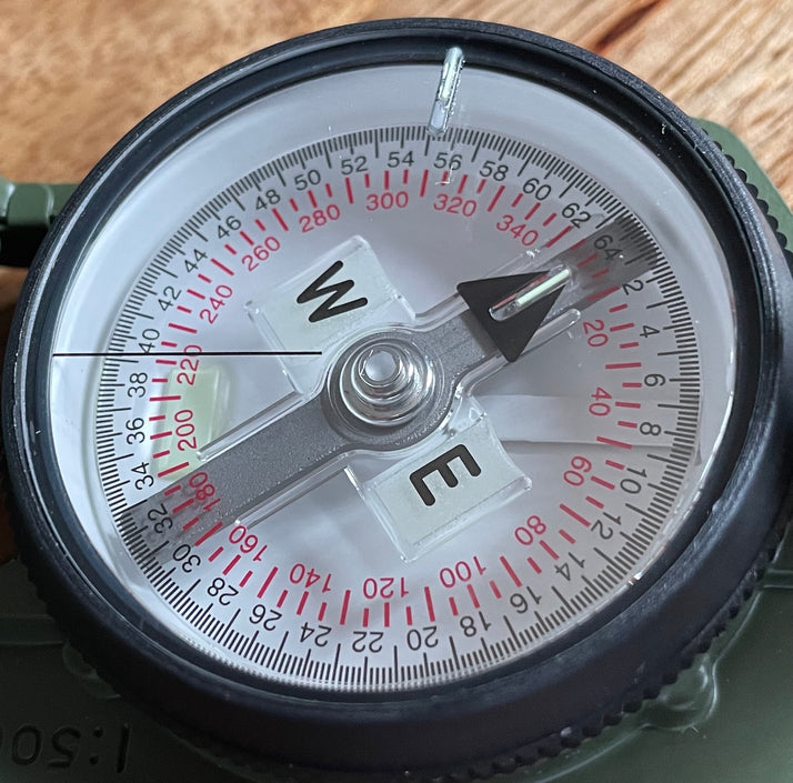Cammenga Military Tritium Lensatic Compass, top view showing the dial, needle, markers and dual gradations.