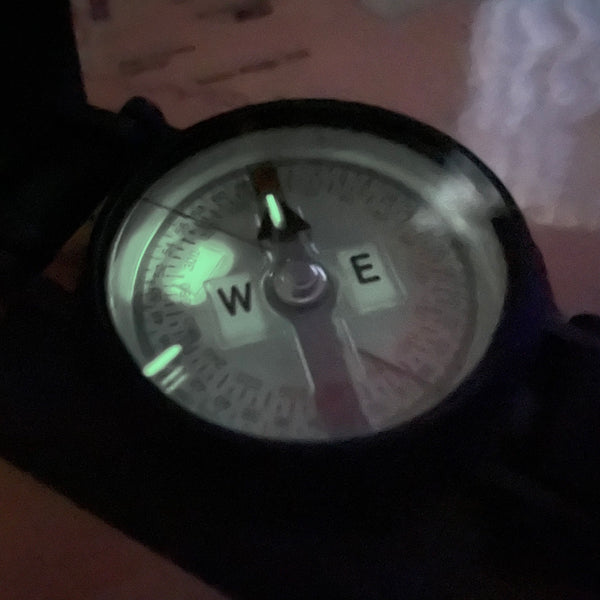 Cammenga Special Tritium Lensatic Compass, oblique night view showing the dial, needle and radioluminescent markers.